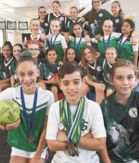 group of twenty Oakleigh South Primary School in sports uniforms, a number with medals around their necks 