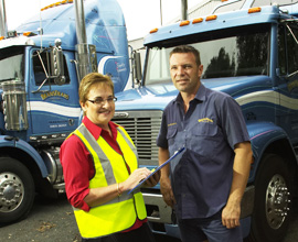 Man and woman standing in front of trucks Man and woman standing in front of trucks
