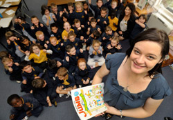 teacher standing in front of students sitting on floor