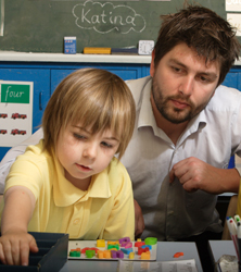 Child playing with blocks with a teacher