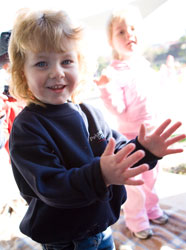 Young girl outside clapping