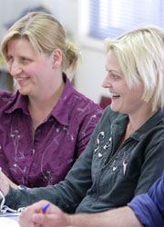 Teachers sitting at desk smiling