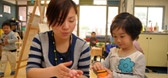 An early childhood professional helping a child with playdough
