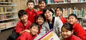 A teacher with a group of young students gathered together