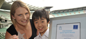 Swimming star Leisel Jones with a young student holding his sports award trophy and certificate
