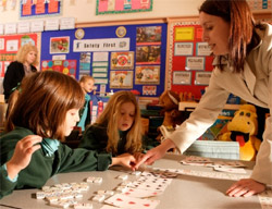 Teacher helping primary school students with maths
