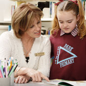 teacher reading to schoolgirl