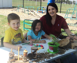 Two children sitting with childcare worker 