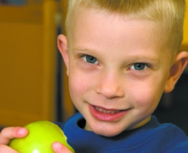 small boy eating an apple