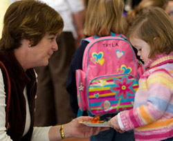 Kindergarten teacher talking to little girl