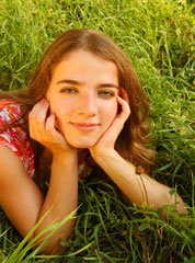 Teen girl lying on grass