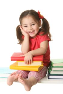Young girl sitting on books