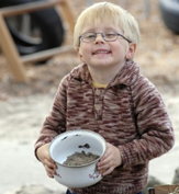 young boy holding a pot plant
