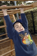 young boy swinging by his arms