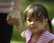 young girl holding hands with an adult
