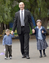 Father walking two children to school
