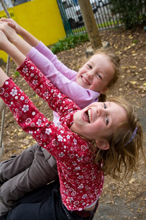 Two girls climbing the ladder in a playground