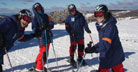 students with skiis on top of slope