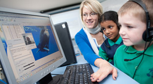 students and teacher in front of computer