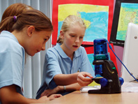 2 students with a microscope