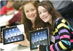 Two girls holding iPads and smiling