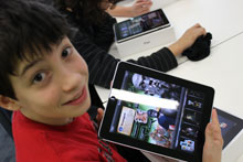 Boy showing iPad to camera