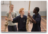 Students in gymnasium with climbing ropes