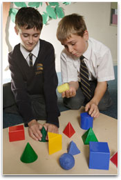 Students in class with blocks of assorted shapes and sizes