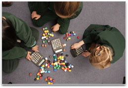 Students in class using calculators and counting blocks