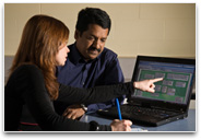 Two teachers with Continuum open on laptop and planning document open on desk