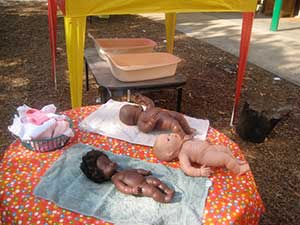 image shows equiptment: 3 dolls, 2 towles, a basket with clothes and 2 baby baths