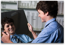 Yr 7 student?s face partially reflected in a plane mirror held at an angle.