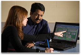 Two teachers with Continuum open on laptop and planning document open on desk