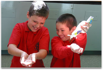 2 students are squelching hair gel and are squeezing toothpaste onto their hands