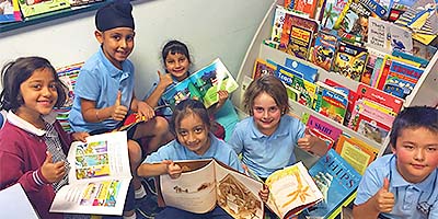 Six Kilberry Valley Primary School students with books gicing the thumbs up 