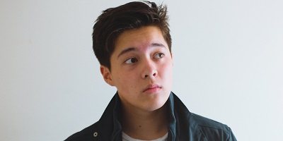 A photo of Jordan Blanch, including his face and shoulders, looking to the side of the camera