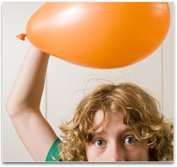 Student holding balloon above head so hair is standing up & attracted to it